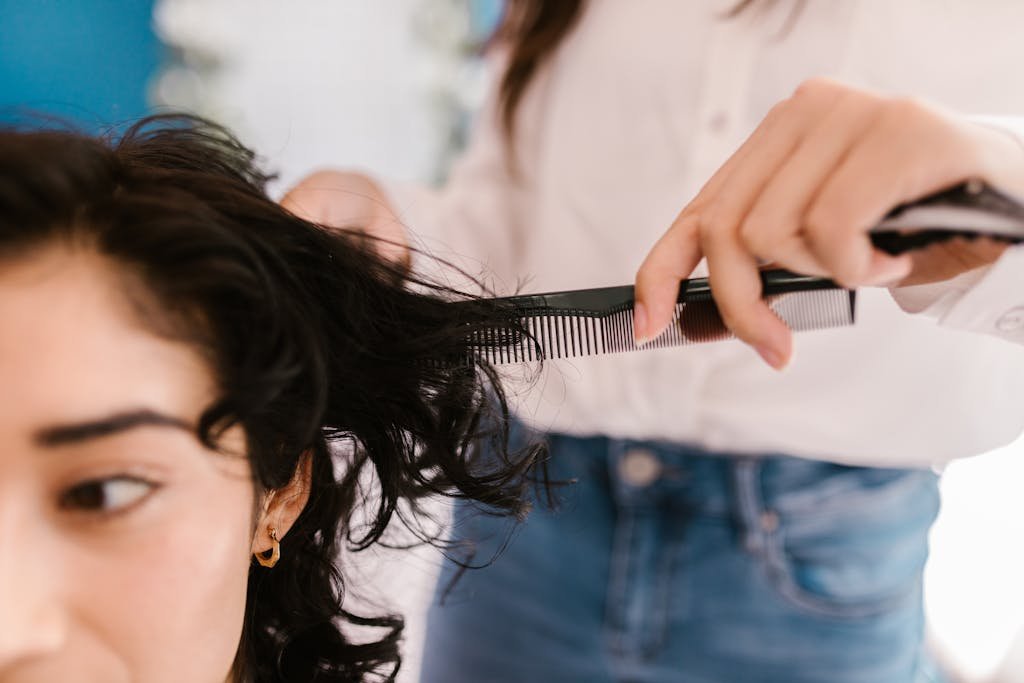 Close-up of hairstylist cutting client's hair in a salon setting.